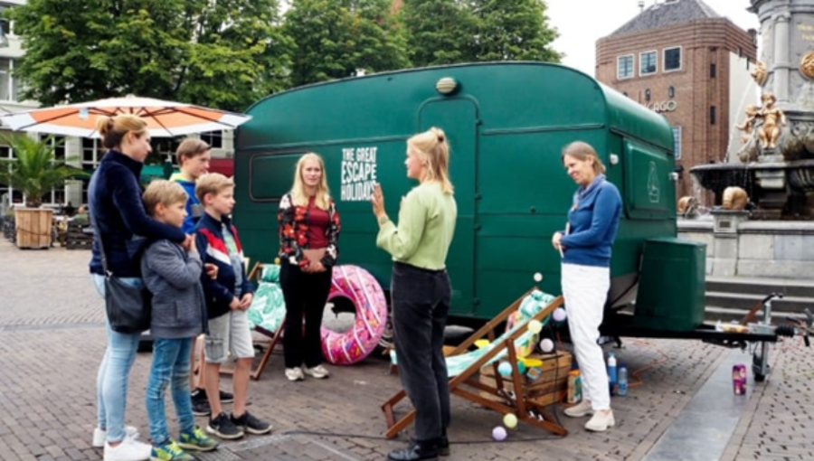Een aantal mensen staan voor de escape caravan over laaggeletterdheid.