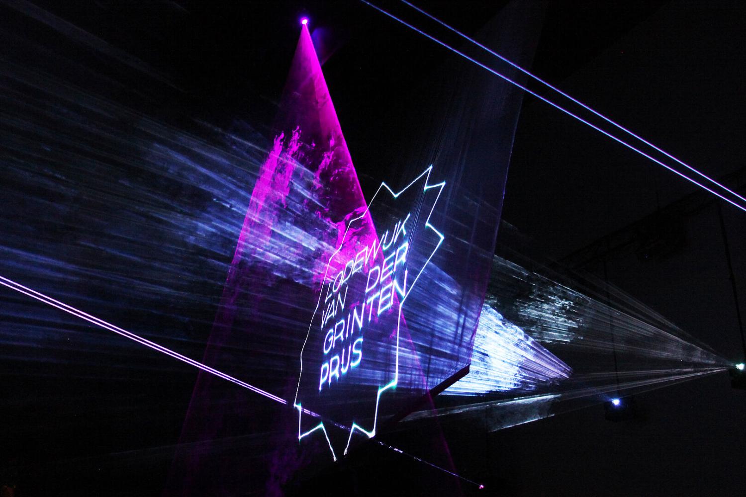 Laserlicht met hierin het logo van de Lodewijk van der Grintenprijs tijdens de uitreiking van de prijs in 2021.