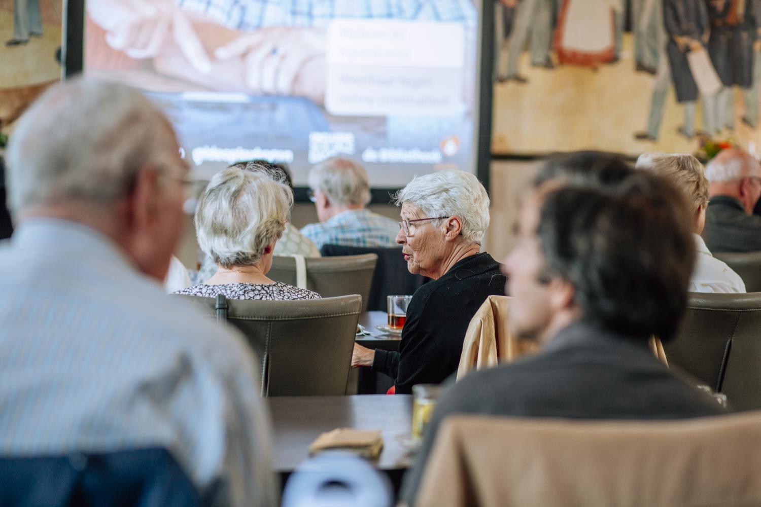 Senioren bij een bijeenkomst in de bibliotheek 