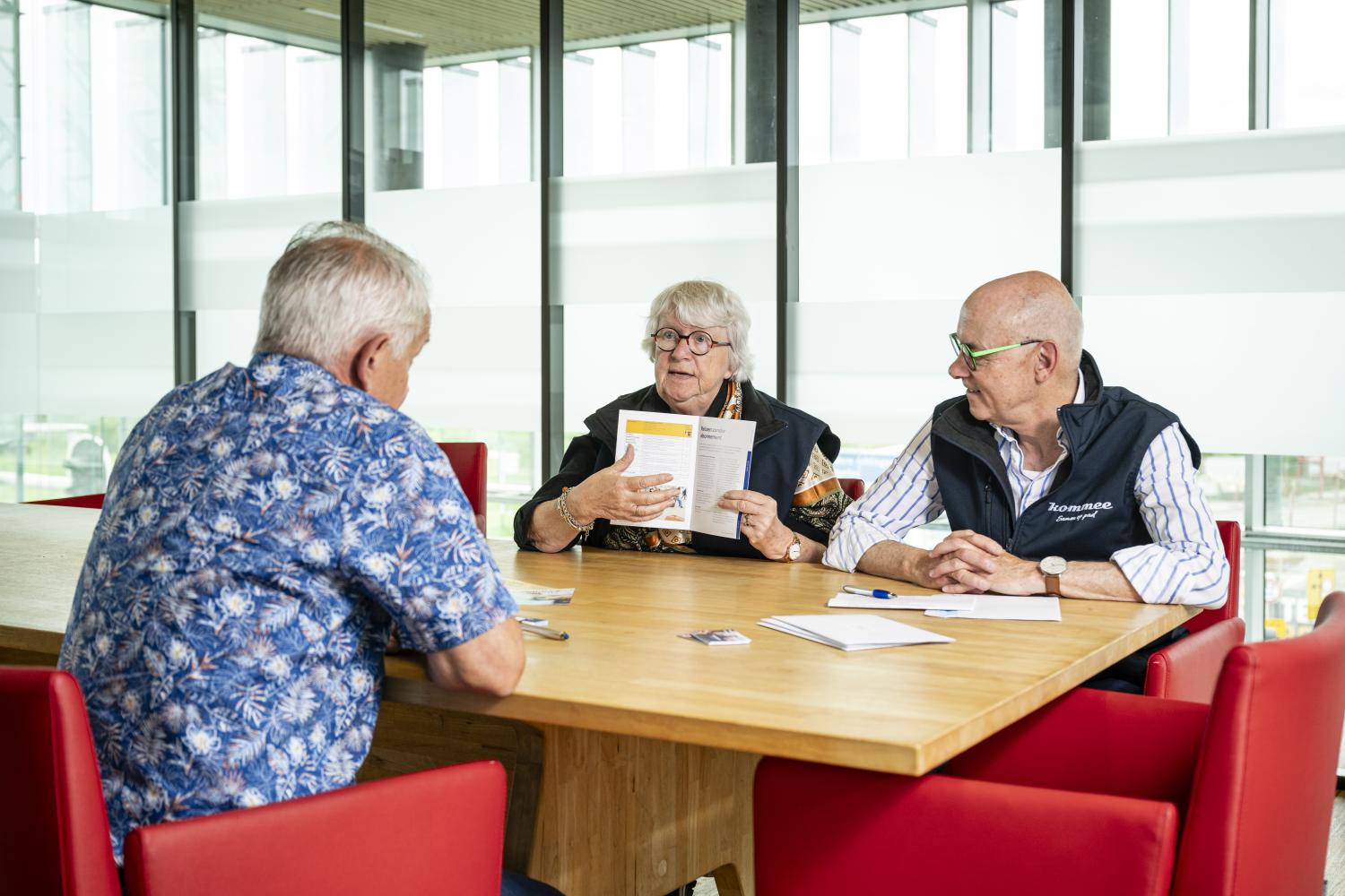iemand die uitleg krijgt aan tafel over reizen met het OV