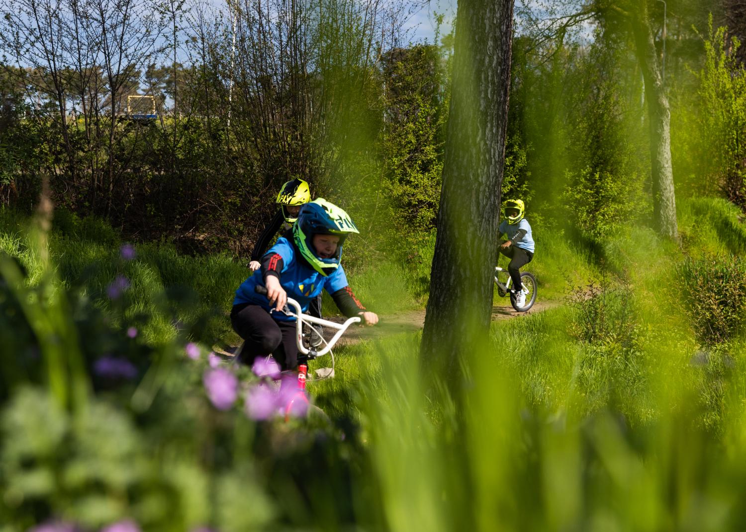 Kinderen die door een park fietsen op BMX fietsen 