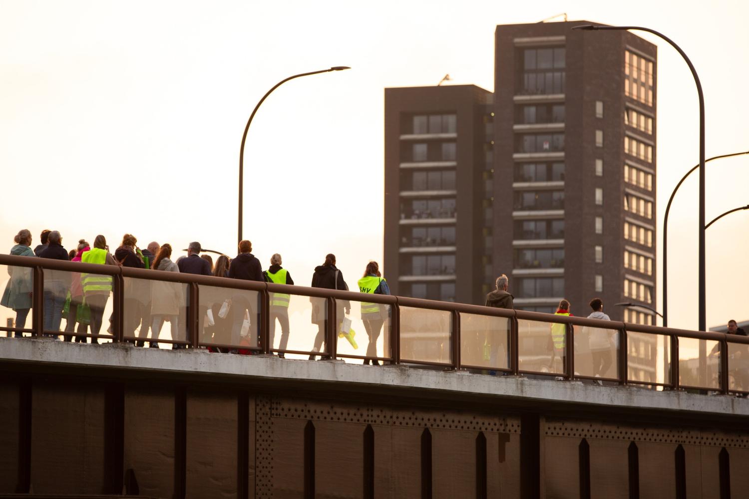 Wandelaars tijdens de Walk into the light op de stadsbrug 