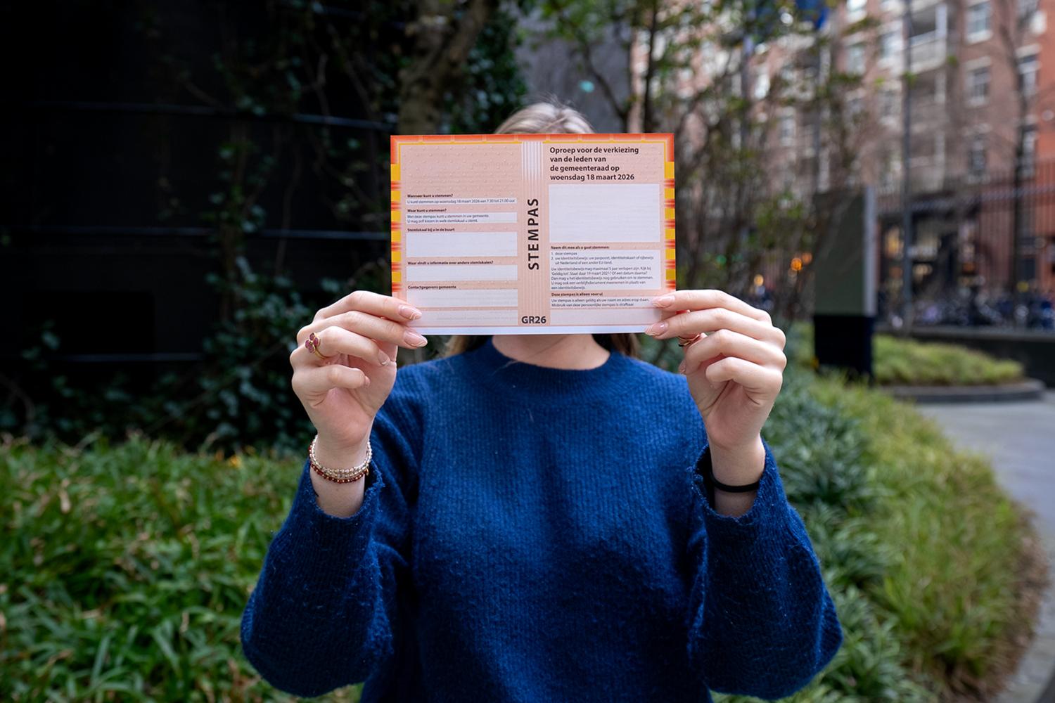 Mevrouw houdt stempas vast voor haar hoofd