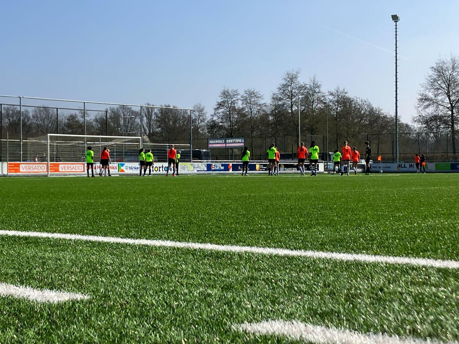 Voetballende kinderen op een voetbalveld