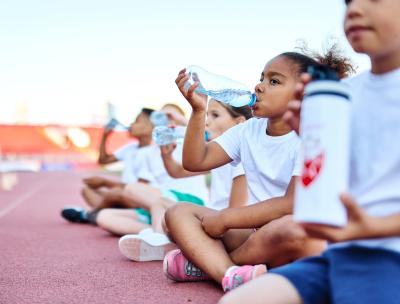 Kinderen die water drinken uit een flesje