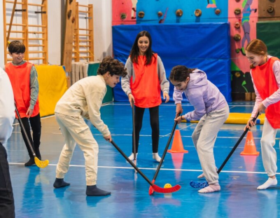 Jongeren die aan het hockeyen zijn in een sportzaal