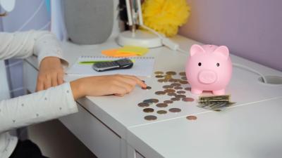 Kind is geld aan het tellen dat uit zijn spaarvarken is gekomen