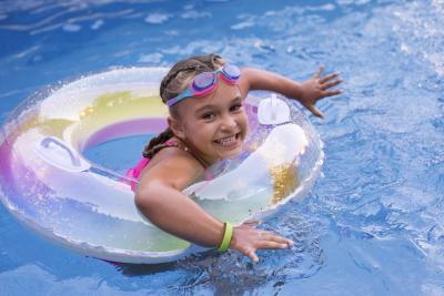 Kind aan het spelen in het water in een opblaasband